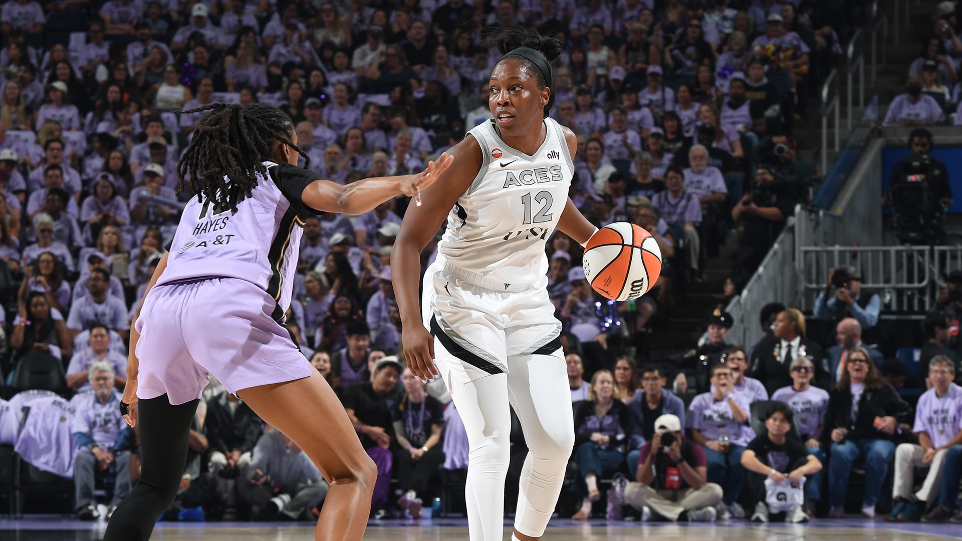 Chelsea Gray of the Las Vegas Aces, wearing a white road jersey, brings the ball up the court against Golden State during Game 1 of the 2026 WNBA semifinals