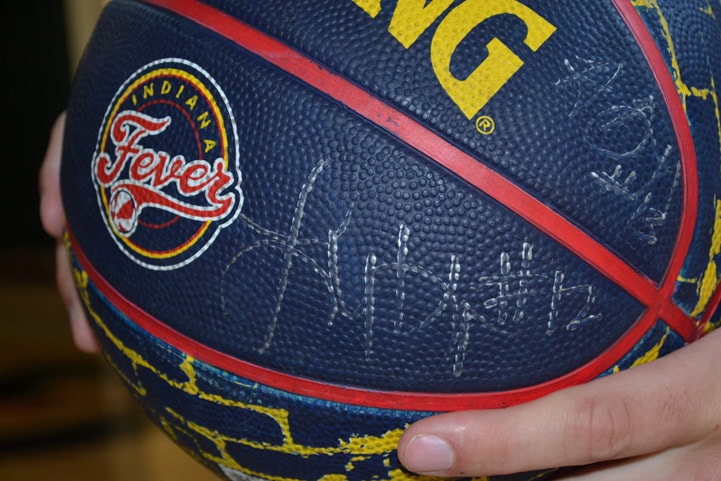 A blue, yellow and red Fever basketball with Lynetta Kizer and Alicia DeVaughn's signature on it.