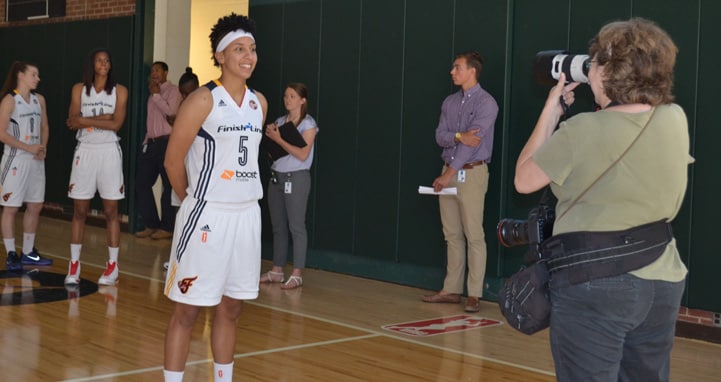 Layshia Clarendon poses for a photo as some of her teammates look on during Indiana Fever Media Day.