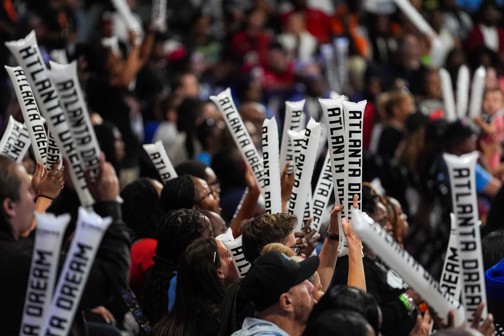 Fans holding thunder sticks at a basketball game