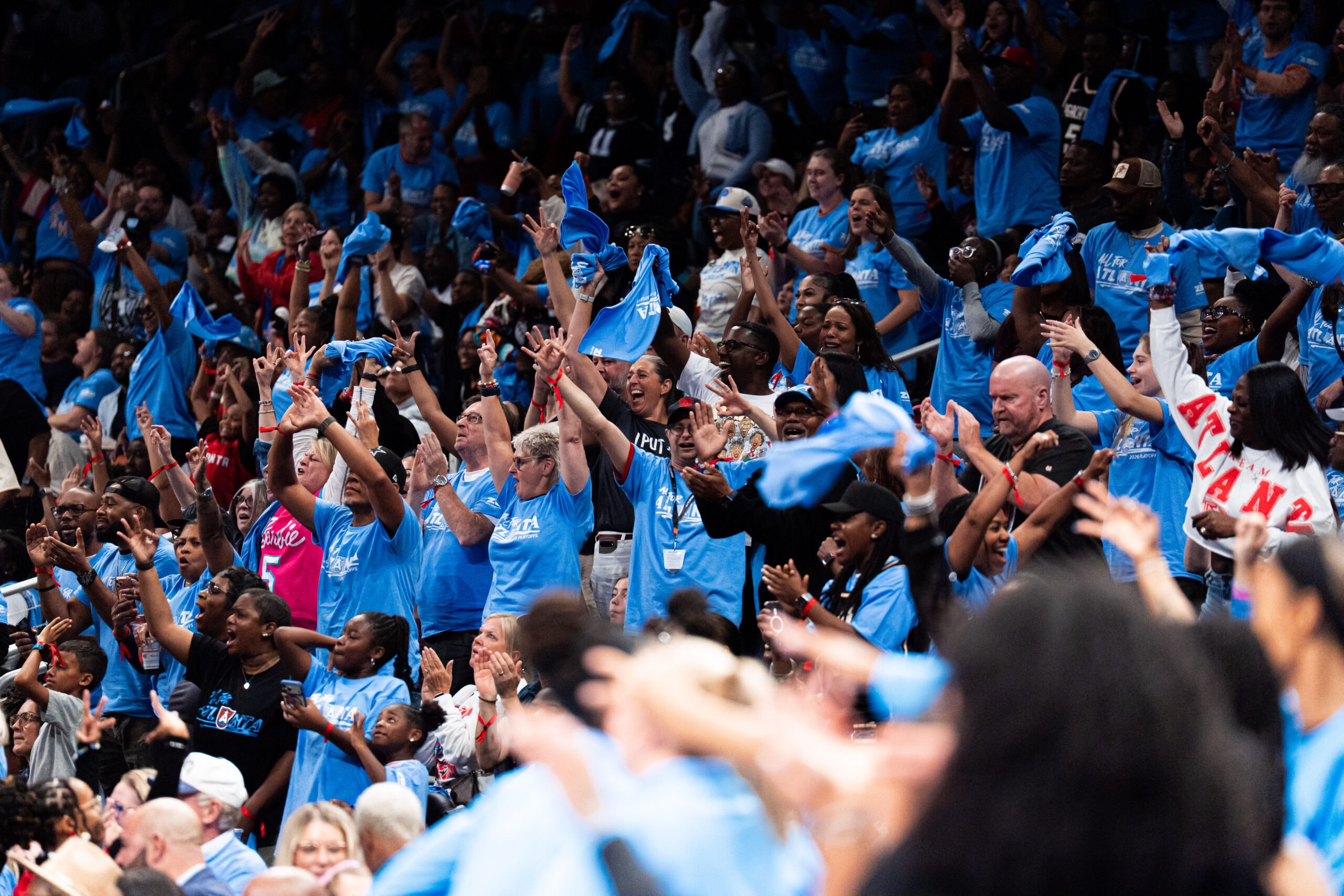 Group of fans at the Atlanta Dream, WNBA Playoff game celebrating.