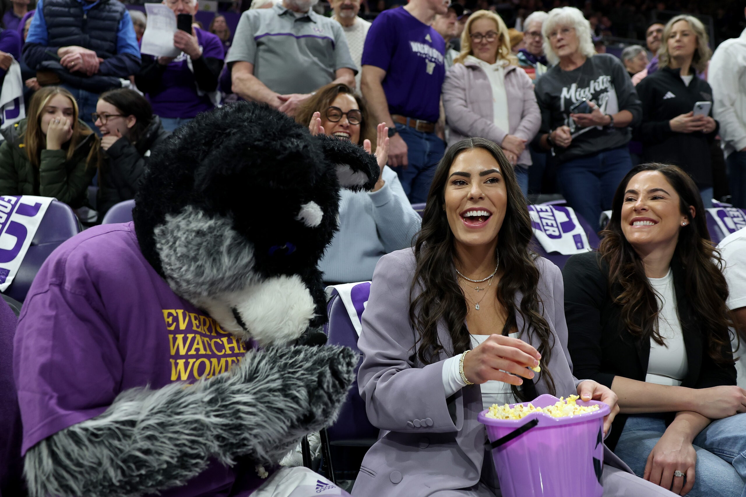 Kelsey Plum eats popcorn with mascot Harry the Husky during her #10 jersey retirement ceremony
