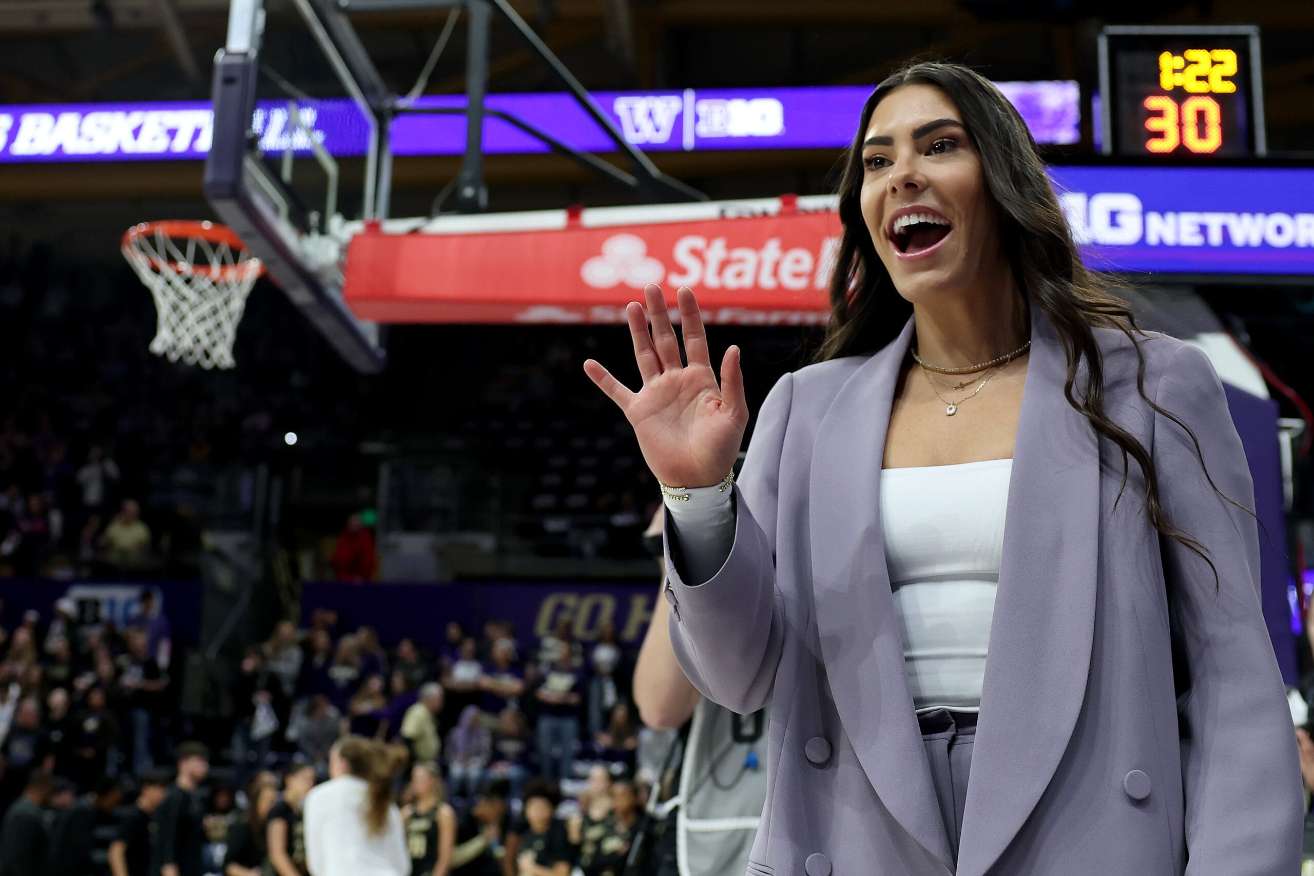 Kelsey Plum smiles and greets the crowd during her jersey retirement ceremony