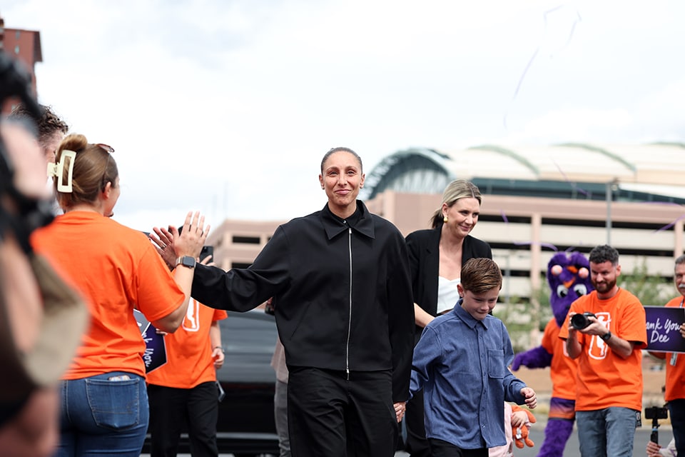 Diana Taurasi walks through a crowd of fans ahead of her retirement press conference