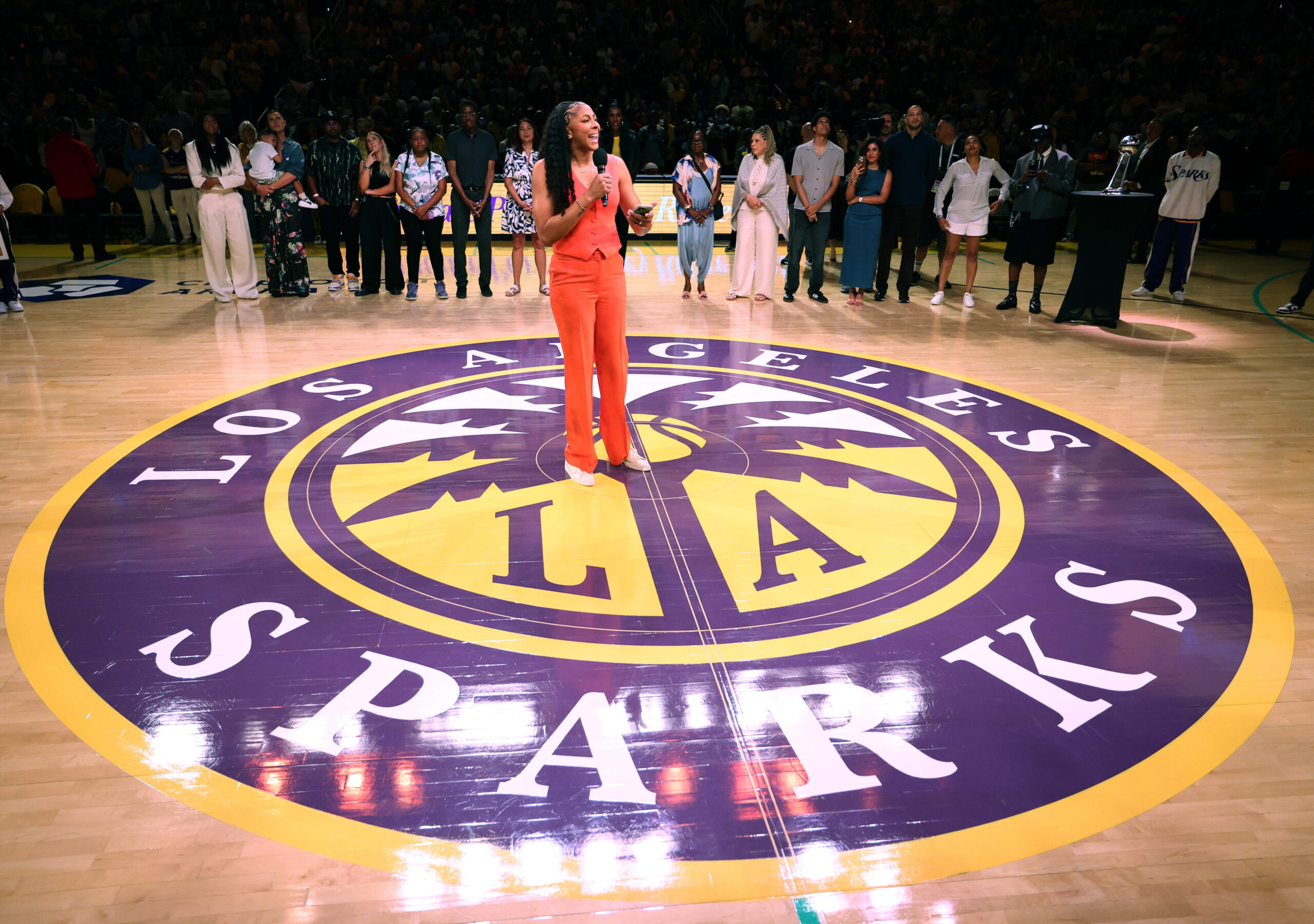 Candace Parker stands on the Los Angeles Sparks logo and speaks during her jersey retirement ceremony