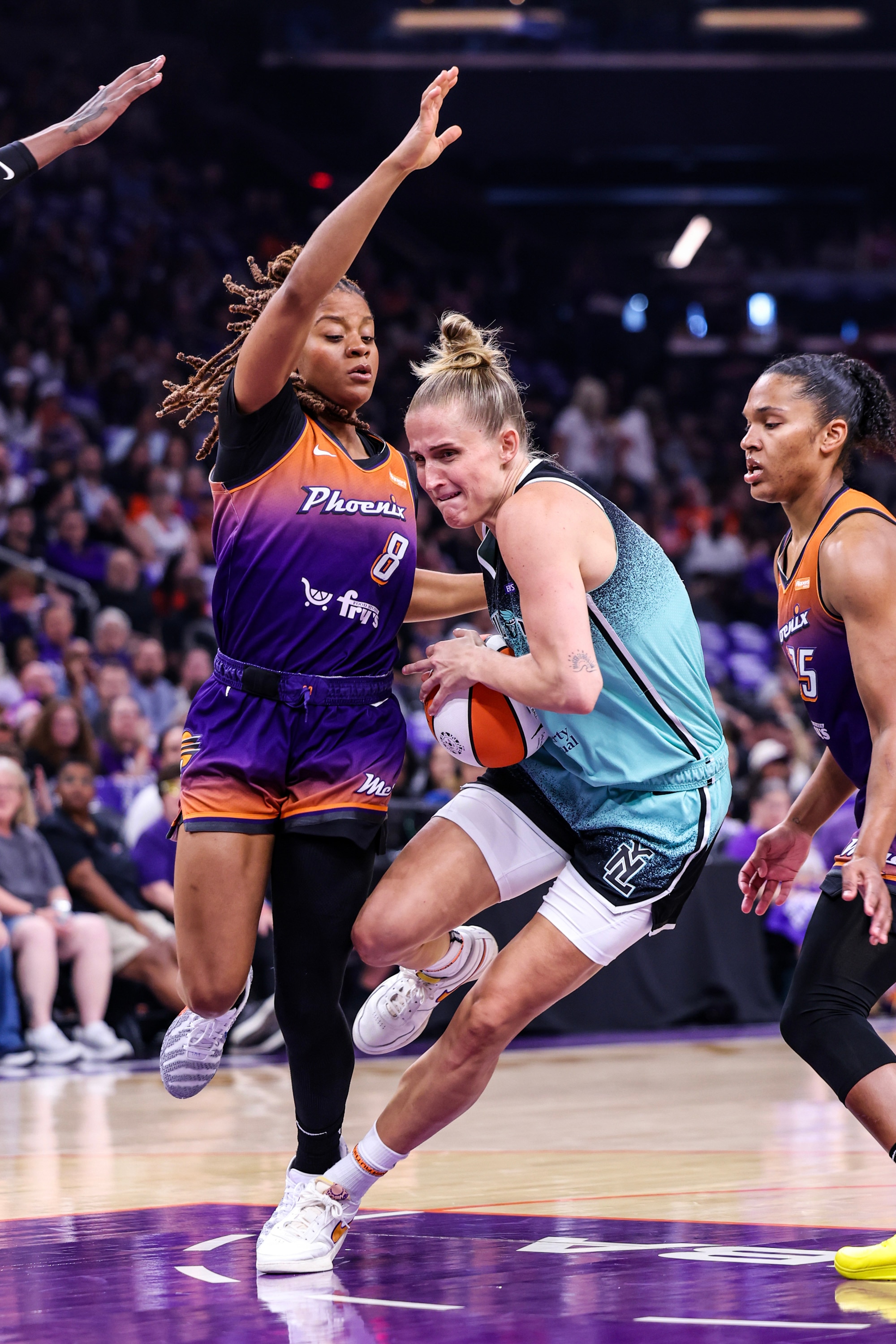Leonie Fiebich #13 of the New York Liberty dribbles the ball while Monique Akoa Makani #8 of the Phoenix Mercury attempts to block her