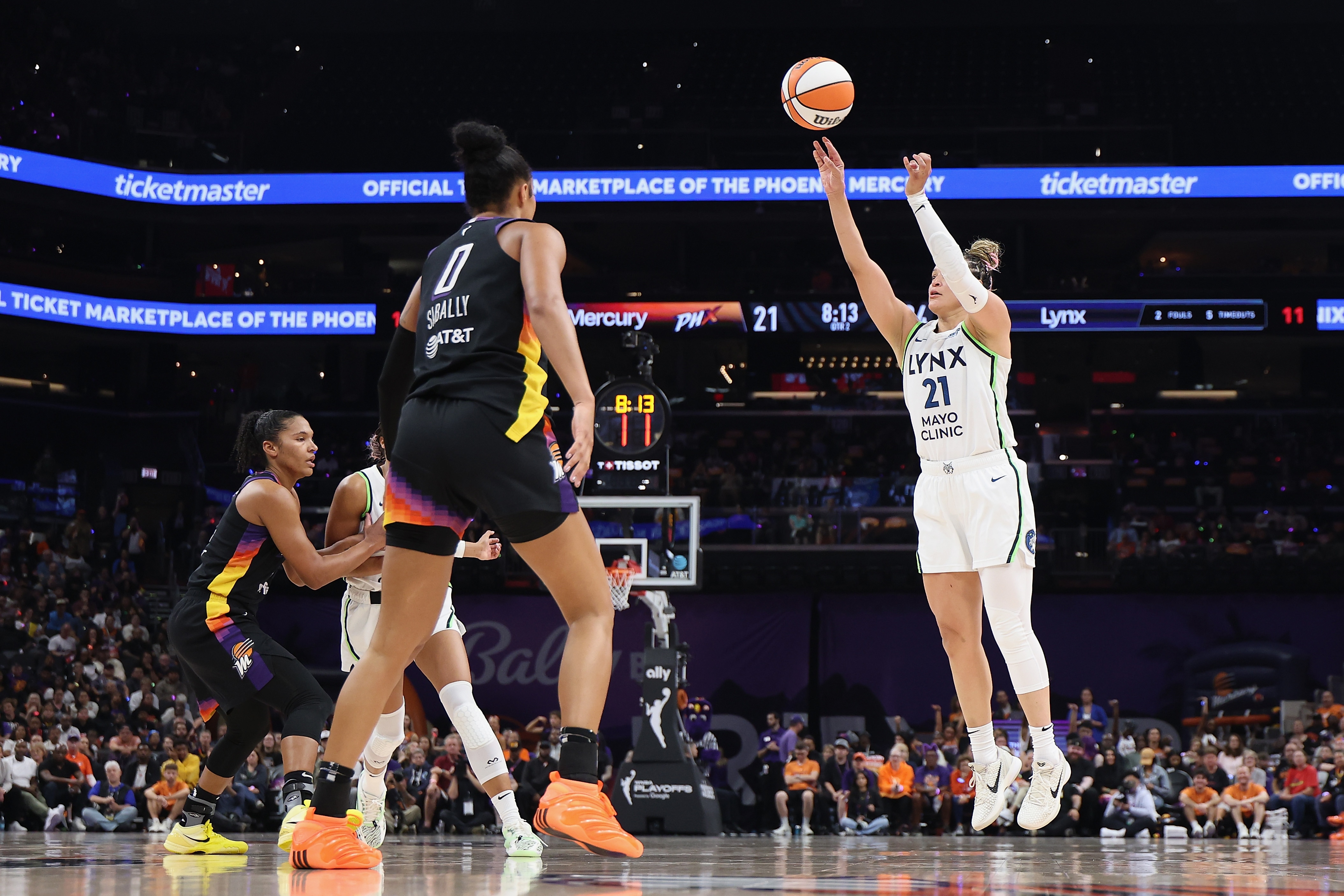 Kayla McBride #21 of the Minnesota Lynx attempts a three-point shot over Satou Sabally #0 of the Phoenix Mercury