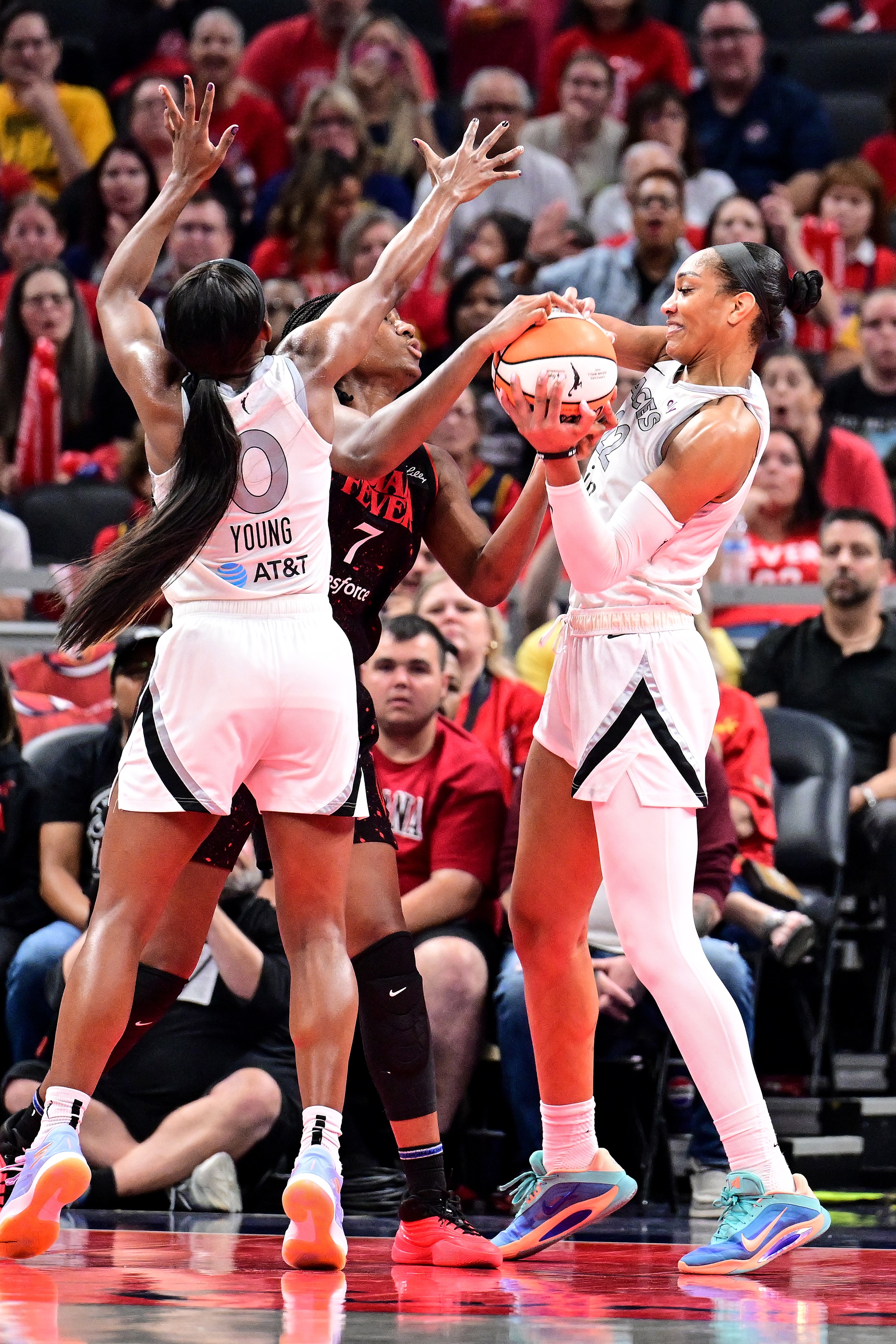 A'ja Wilson #22 of the Las Vegas Aces and Aliyah Boston #7 of the Indiana Fever get tied up
