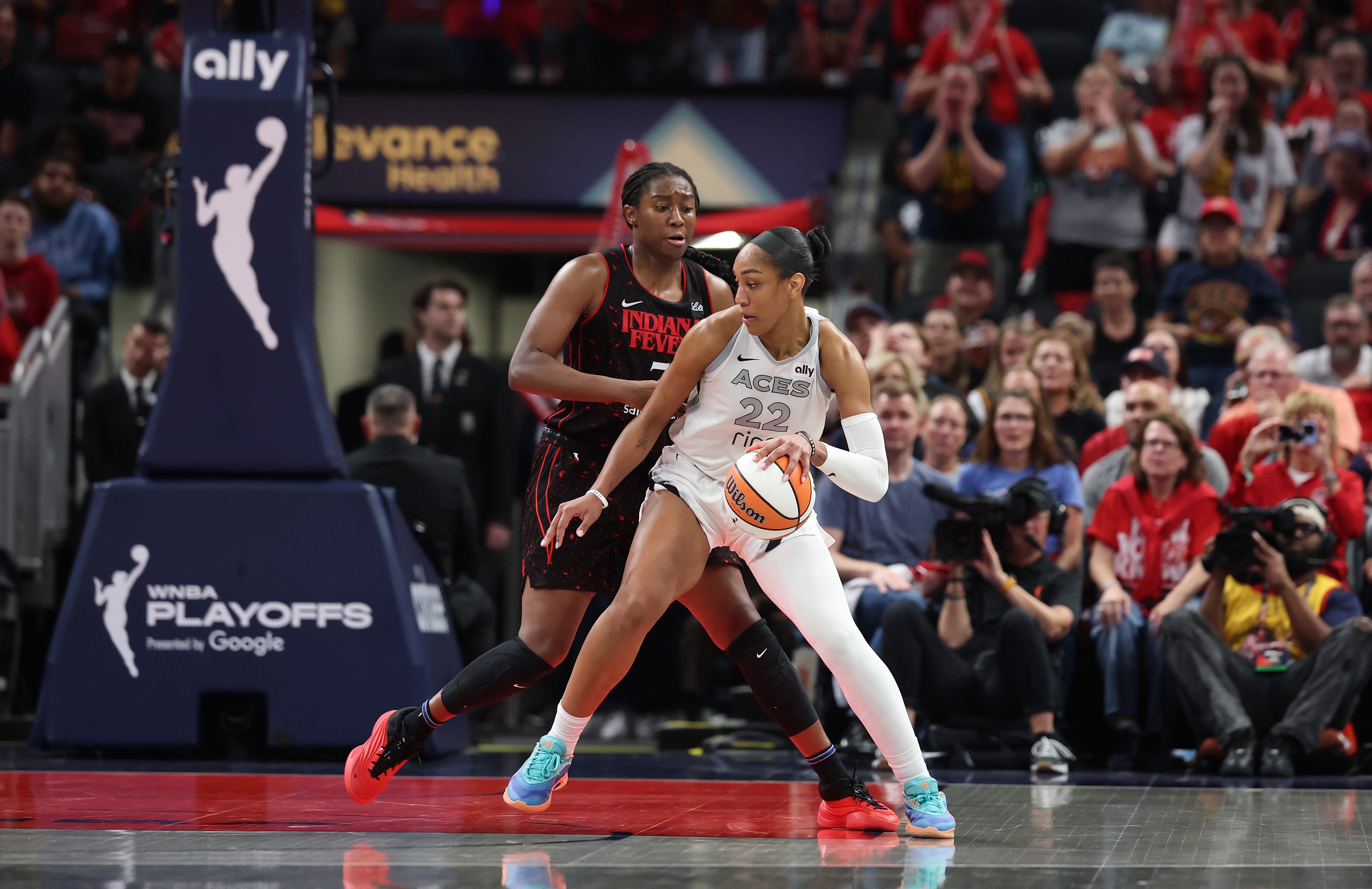 A'ja Wilson #22 of the Las Vegas Aces dribbles the ball while defended by Aliyah Boston #7 of the Indiana Fever