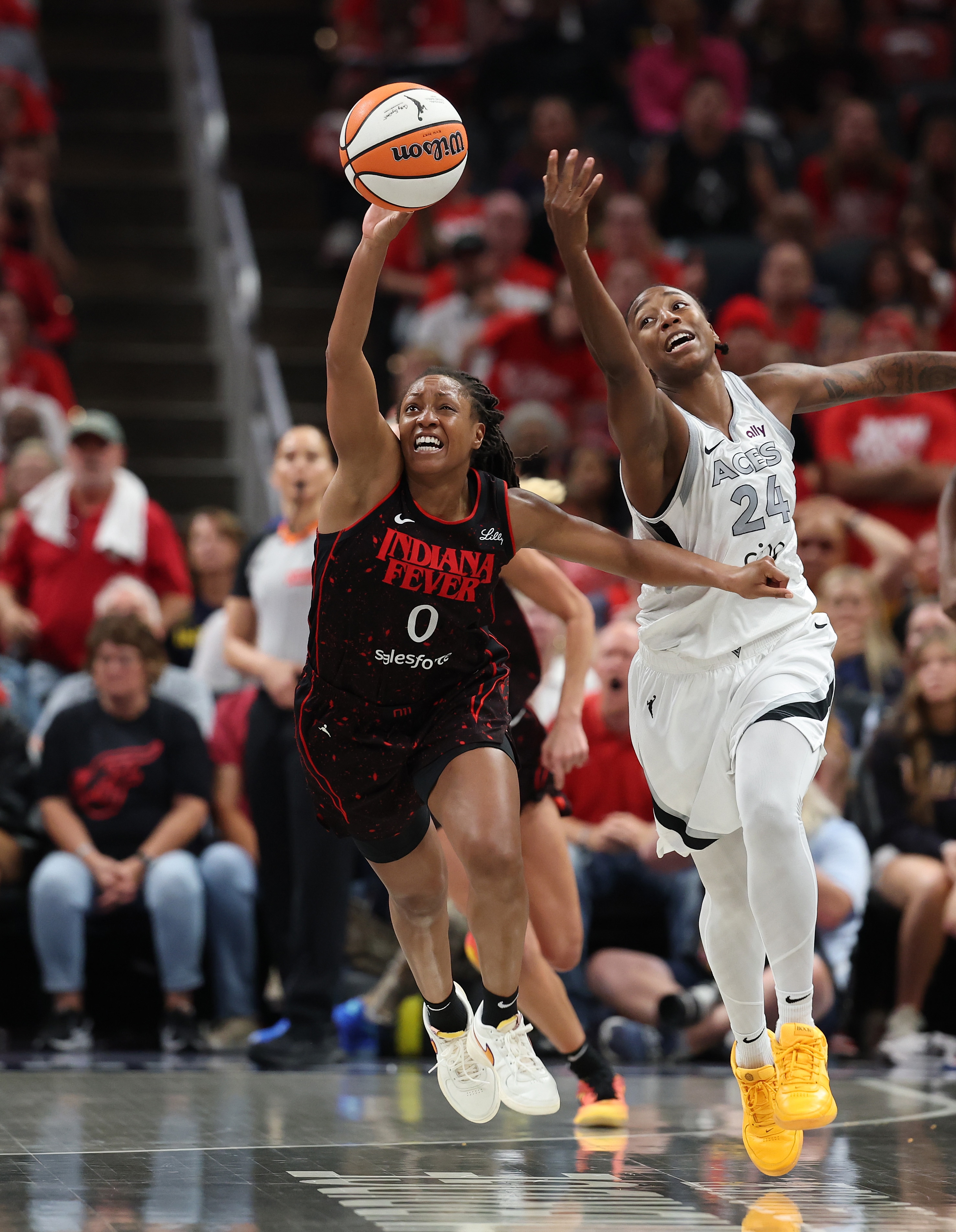Kelsey Mitchell #0 of the Indiana Fever and Jewell Loyd #24 of the Las Vegas Aces battle for a loose ball