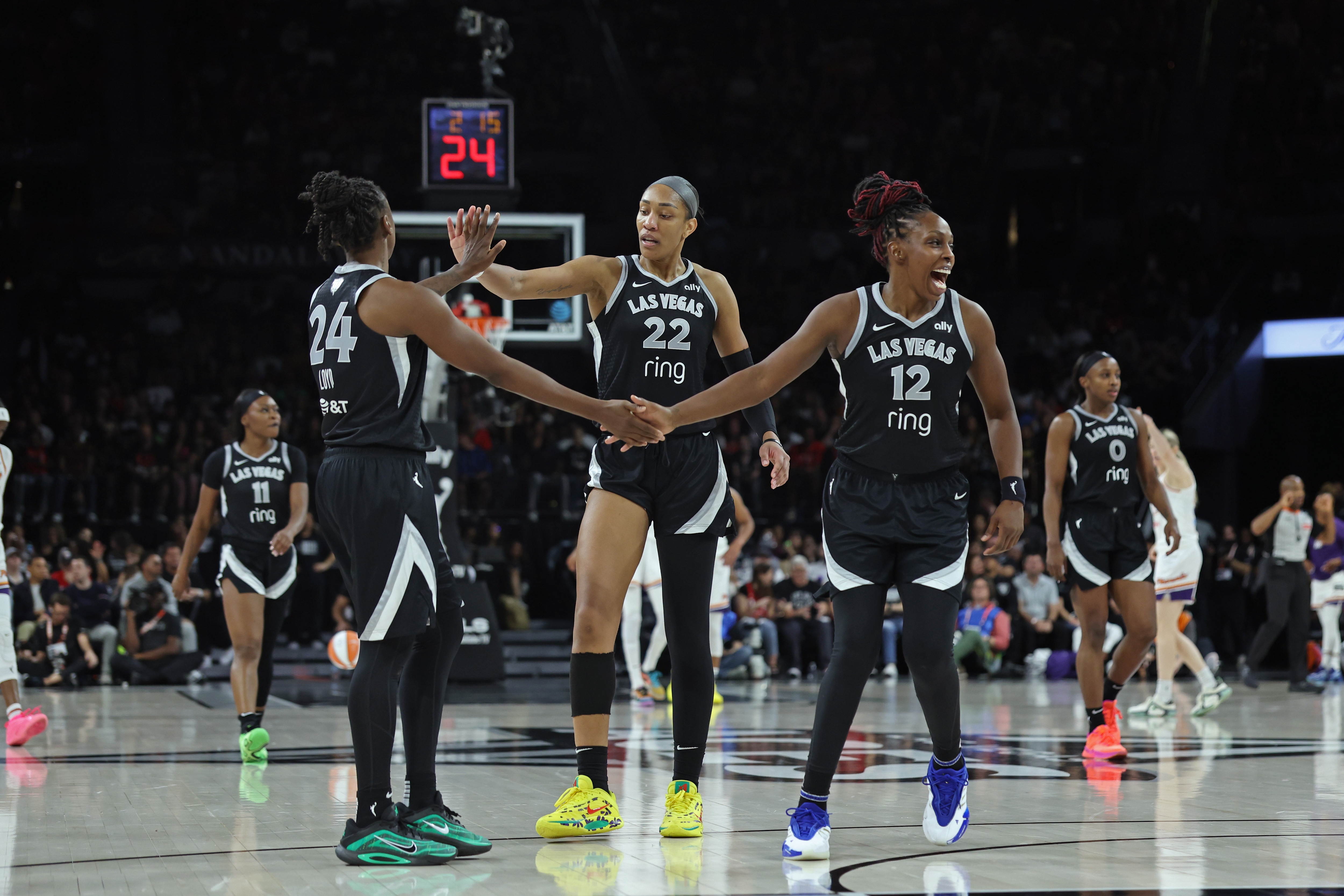 Jewell Loyd #24, A'ja Wilson #22 and Chelsea Gray #12 of the Las Vegas Aces high five during the game against the Phoenix Mercury