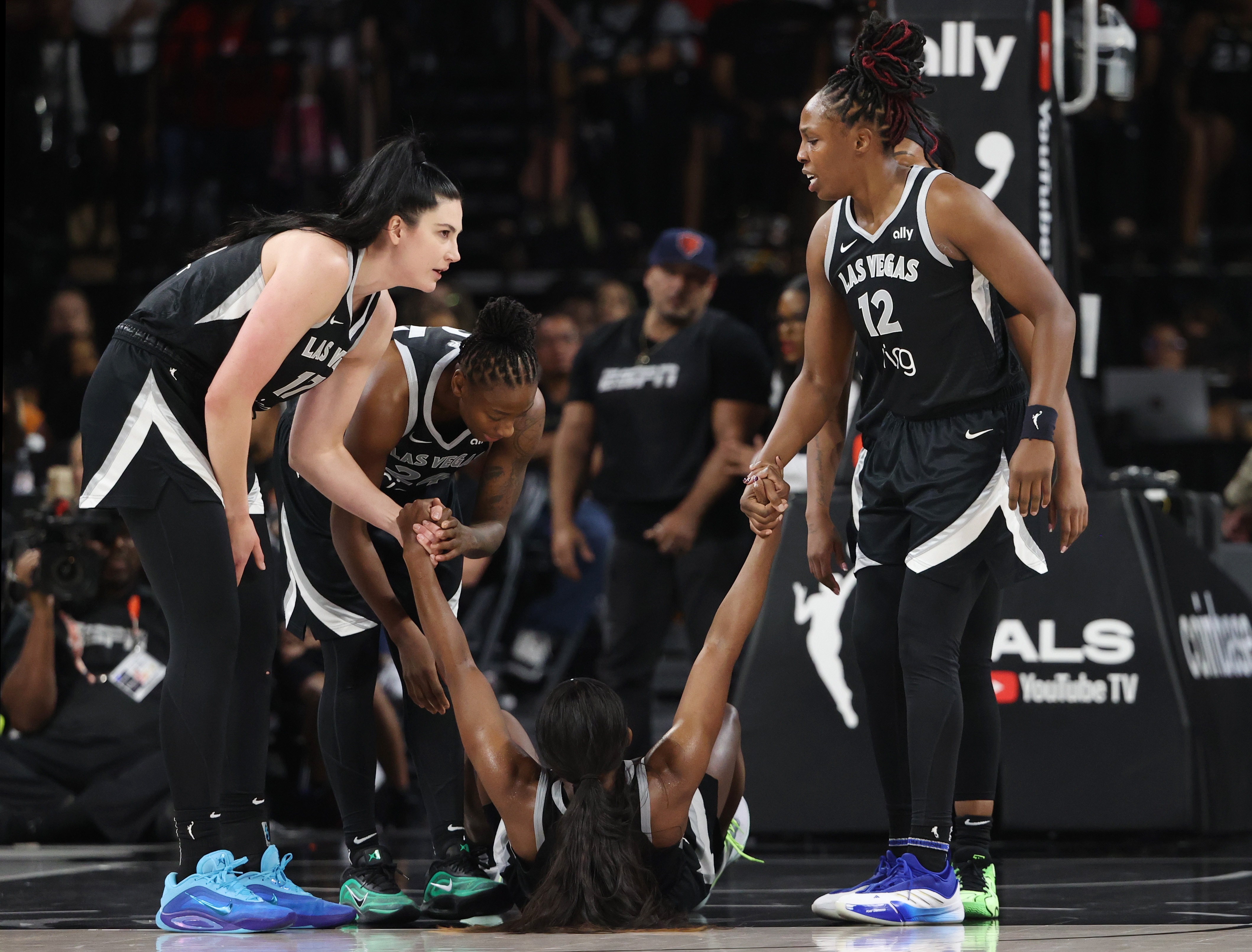 Jackie Young #0 of the Las Vegas Aces is helped to her feet by teammates