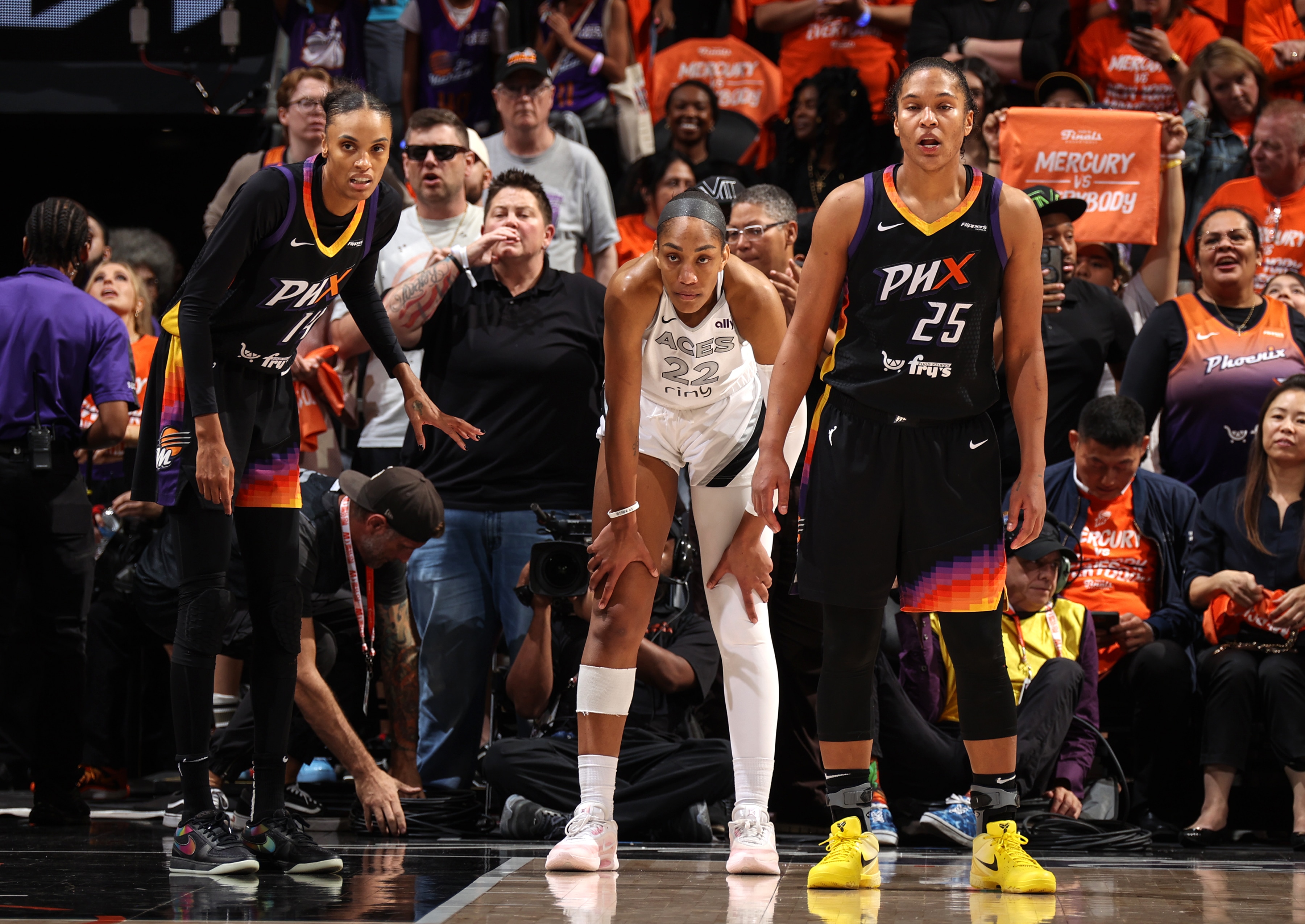 DeWanna Bonner #14 of the Phoenix Mercury, A'ja Wilson #22 of the Las Vegas Aces and Alyssa Thomas #25 of the Phoenix Mercury look on during the game