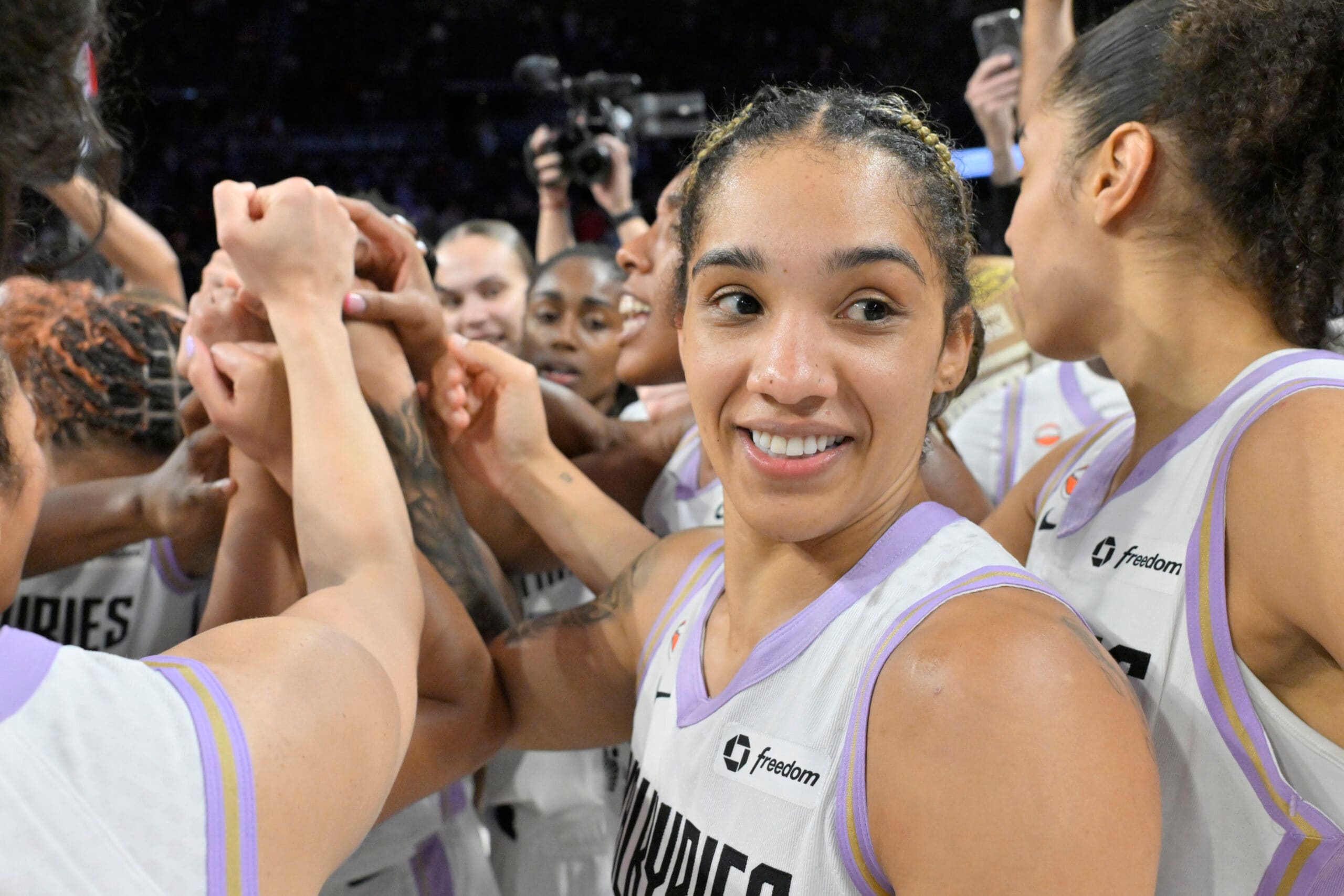 Players contest a shot near the basket during a WNBA game